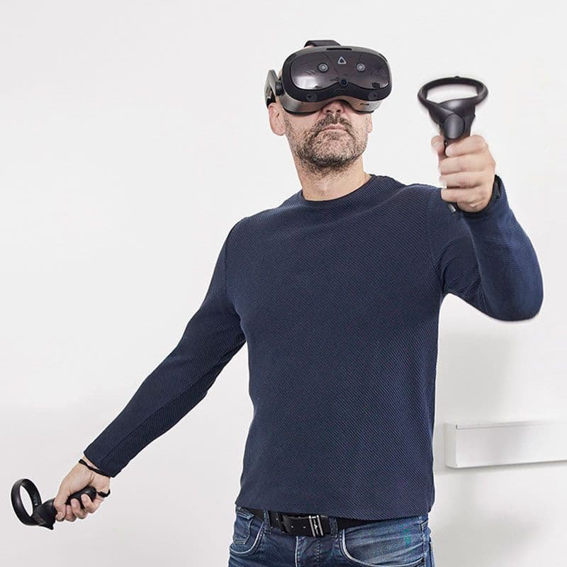 En ældre mand holder BalanceVR-enheden i sine hænder.
